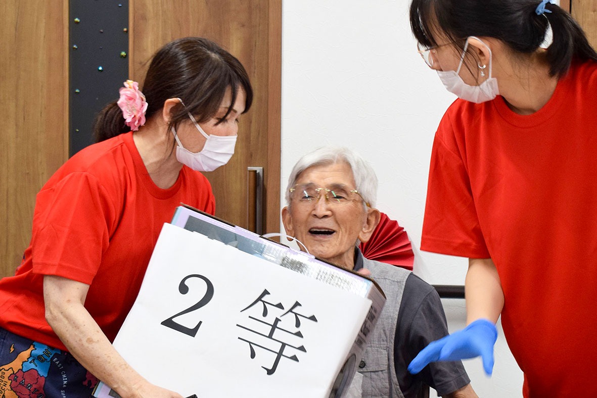 デイサービスのビンゴ大会で2等が当たって喜ぶ男性